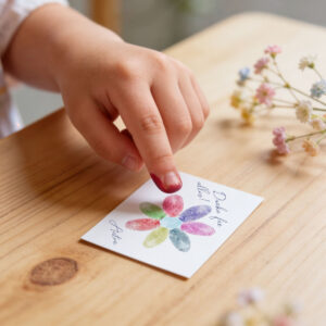 Kind macht aus Fingerabdrücken eine Blume auf Geschenkkarte